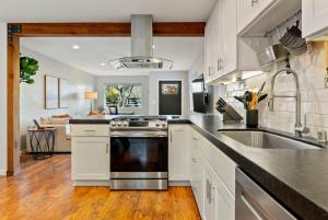 a kitchen with a sink and a stove at Templeton Creekside Cottage Walk to Downtown in Templeton
