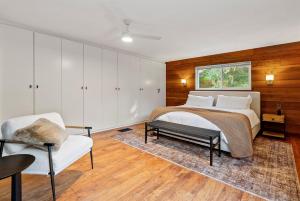 a bedroom with a bed and a couch and a chair at Templeton Creekside Cottage Walk to Downtown in Templeton