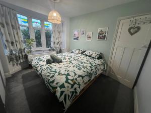 a bedroom with a bed with a floral bedspread at Summer Salt house in Morecambe