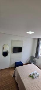 a bedroom with a bed in a room with a window at Paris Flats Lagoa Santa in Lagoa Santa