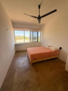 a bedroom with a bed and a ceiling fan at Pool, Space, Style, Modern House for 8 in Brisas de Zicatela