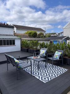 a patio with two chairs and a table on a deck at Cockle Cottage in The Mumbles