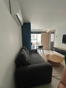 a living room with a black couch and a table at Studio 2 personnes maximum in Saint-Andiol