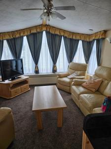 a living room with a couch and a flat screen tv at Bella in Skegness