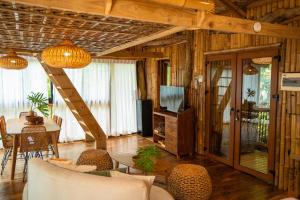 a living room with a television and a table and chairs at Treehouse de Valentine in Balamban +114 photos
