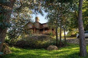 a log house sitting on a hill in the woods at Cabañas San Michele in La Cumbrecita