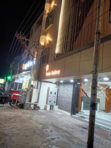 an empty street in front of a building at night at Femina Residency in Kumbakonam
