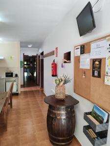 a room with a table and a tv on a wall at O Solpor Fillobal in Vilar