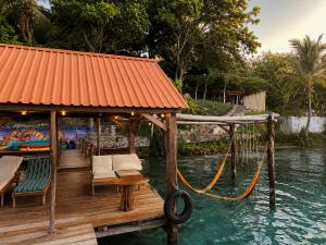 a dock with chairs and a hammock in the water at Villas Karalv in Bacalar +27 photos