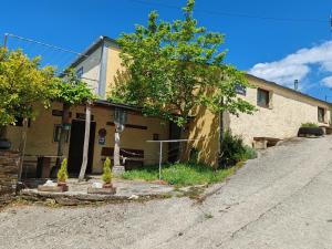 a house with a tree next to a street at O Solpor Fillobal in Vilar