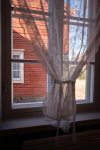 a window with a curtain in front of a house at Gården in Östersolf +71 photos