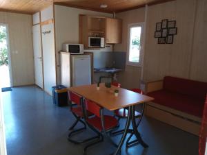 a kitchen with a table and chairs and a couch at Adapted chalet in La Chapelle-Taillefert
