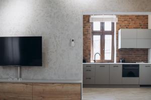 a kitchen with a flat screen tv on a wall at Apartament Centrum Żywiec - PILSKO in Żywiec