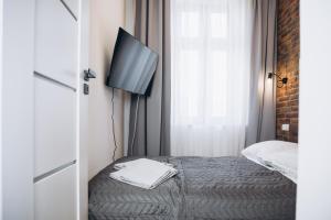 a bedroom with a bed with a flat screen tv at Apartament Centrum Żywiec - PILSKO in Żywiec +29 photos