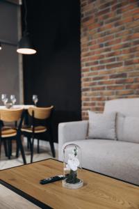 a table with a glass container with a white flower on it at Apartament Centrum Żywiec - PILSKO in Żywiec