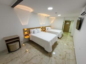 a hotel room with two beds and a television at Hotel Aikos in Yumbo +15 photos