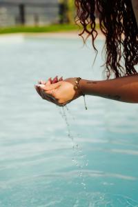 a woman is pouring water from her hand into the water at Quinta de Reis in Ponte da Barca +51 photos