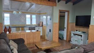 a living room with a couch and a table and a kitchen at Complejo rural Alhelí - Apartamentos y habitaciones in Valdredo