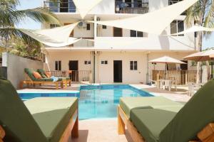 a swimming pool with chaise lounge chairs and a building at Montero Residences in Brisas de Zicatela