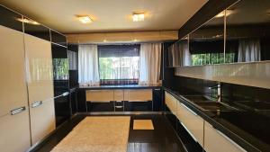 a kitchen with black and white cabinets and a window at SIMPLE BUCHAREST SELF CHECk IN in Bucharest