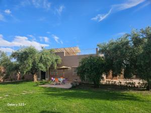 a building with a yard with tables and chairs at Villa du bonheur Chambres d'hote in Ouled el guerne