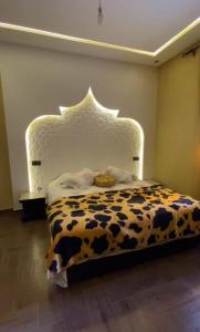 a bedroom with a bed with a cow print headboard at Villa du bonheur Chambres d'hote in Ouled el guerne +10 photos