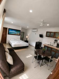 a living room with a bed and a couch and a table at Villas Karalv in Bacalar