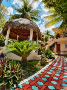 a house with a palm tree and a brick walkway at Villas Karalv in Bacalar
