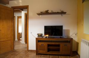 a living room with a television on a wooden cabinet at Casa Rural La Vereilla in Barajas de Gredos
