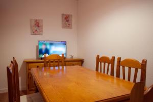 a dining room with a table and a television at Casa Rural La Vereilla in Barajas de Gredos +27 photos