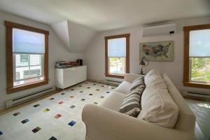 a living room with a white couch and windows at Sleeping Sailor in Camden