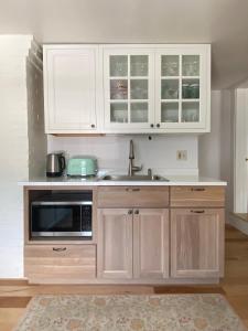 a kitchen with white cabinets and a sink and a microwave at Sleeping Sailor in Camden +14 photos