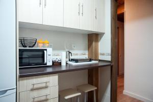 a kitchen with white cabinets and a microwave at Casa Rural La Vereilla in Barajas de Gredos