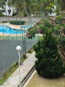 a street light next to a bush with a tree at Rose Condo@ Cocobay Beach Resort in Port Dickson