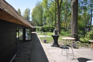 a man standing behind a table in a garden at Hoeve 't Peerdeke in Breda