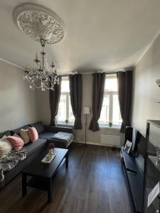 ein Wohnzimmer mit Sofa und Kronleuchter in der Unterkunft Harmony in Oslo