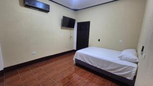 a bedroom with a bed and a flat screen tv at Estadía Climatizada en Escuintla in Escuintla