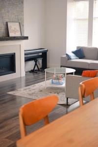 a living room with a couch and a table and a piano at Modern 3 bedroom duplex home in Langley in Langley