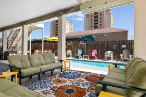 a patio with lounge chairs and a swimming pool at House of Neptune Steps from the sea and private pool in South Padre Island