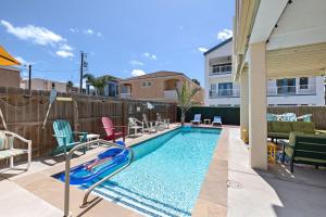 a swimming pool with chairs and a slide in a backyard at House of Neptune Steps from the sea and private pool in South Padre Island