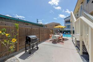 a patio with a grill and a table with a table at House of Neptune Steps from the sea and private pool in South Padre Island