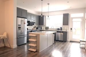 a kitchen with gray cabinets and a white counter top at Modern 3 bedroom duplex home in Langley in Langley