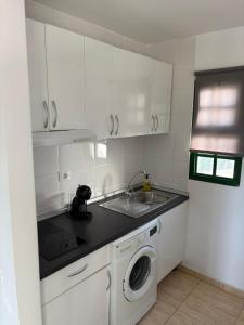 a white kitchen with a sink and a washing machine at Santa Úrsula 66 in Costa Calma +3 photos