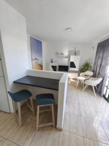 a room with a counter with chairs and a table at Santa Úrsula 66 in Costa Calma
