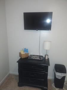a black dresser with a lamp and a television on a wall at Lil ranch in White Pine