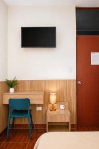 a room with a bed and a chair and a television at Fanda in Sauce