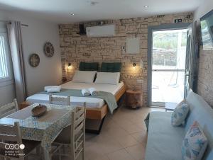 a bedroom with two beds and a table and a dining room at AJ studios by the Sea in Kithnos
