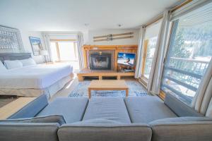 a bedroom with a couch and a bed and a fireplace at Lenawee 1728 by SummitCove Lodging in Colorado in Keystone