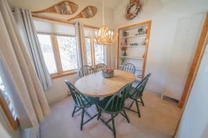 a dining room with a table and chairs and a chandelier at Lenawee 1728 by SummitCove Lodging in Colorado in Keystone