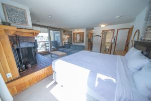 a bedroom with a large bed and a fireplace at Lenawee 1728 by SummitCove Lodging in Colorado in Keystone